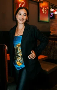 Vanesa Allende con blazer negro y top azul en restaurante - retrato de personal branding