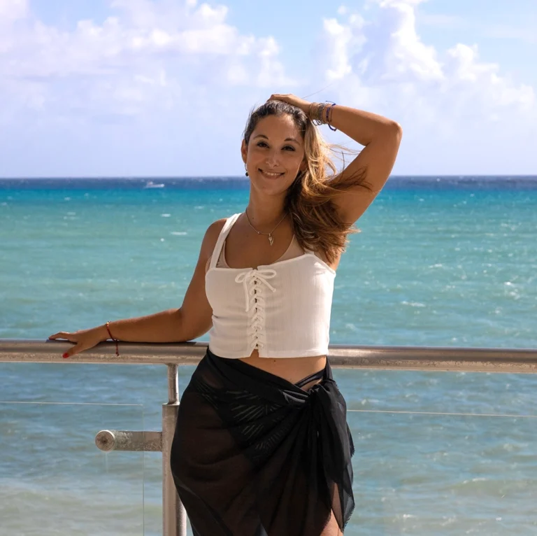 Vanesa Allende sonriendo en terraza frente al mar turquesa del Caribe