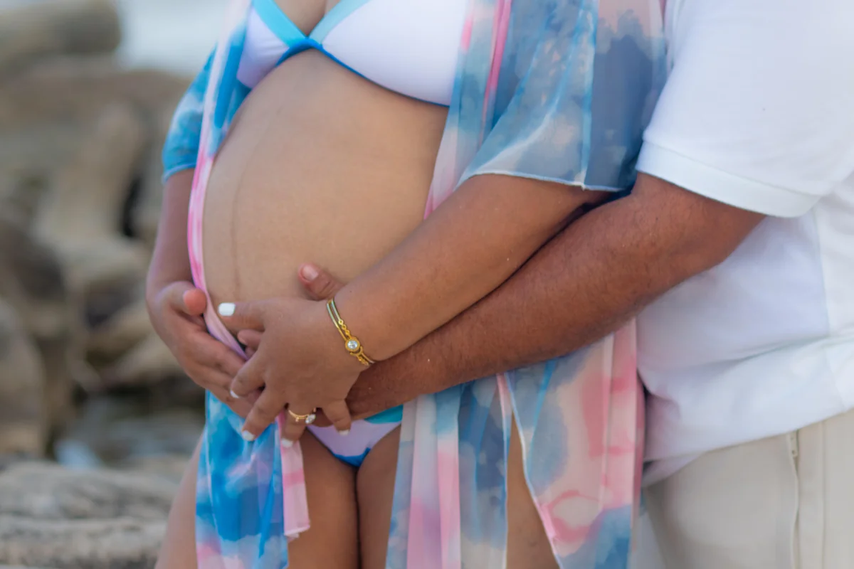 Pregnant woman in beach maternity photoshoot with sunset backdrop, maternity photography Playa del Carmen