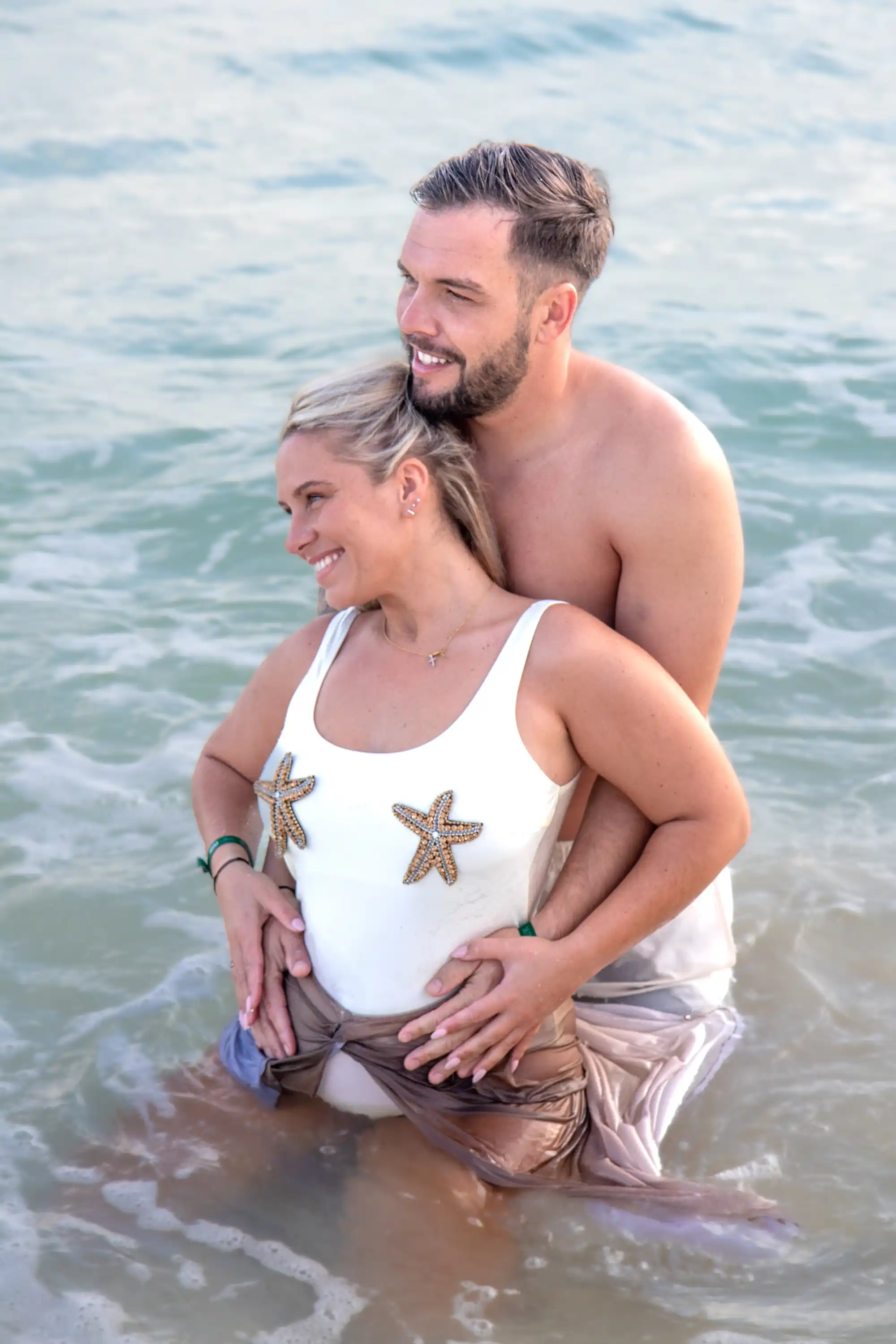 Expecting couple in the ocean during maternity photography session in Playa del Carmen – in-water baby bump photo