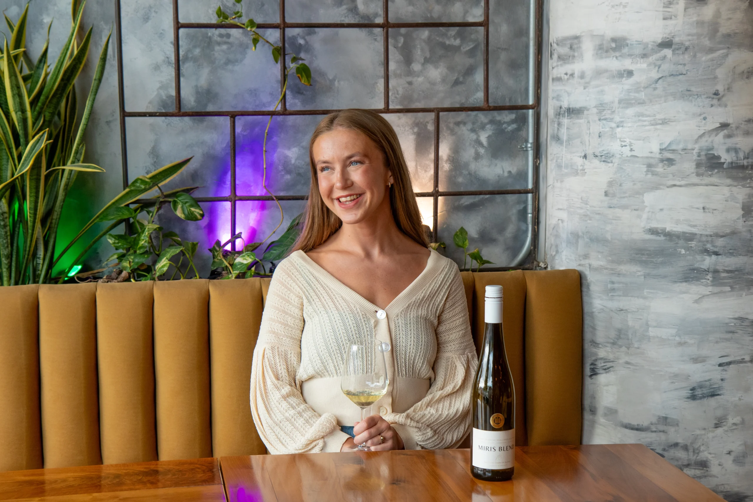 Mujer rubia sonriendo sentada en restaurante elegante - personal branding femenino