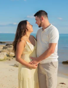 Beautiful pregnant woman holding baby ultrasound photos on the beach in Playa del Carmen, Mexico