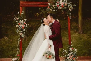 Wedding photographer in Riviera Maya – bride and groom under floral arch at destination wedding in Costa Rica, Joice Dahianna